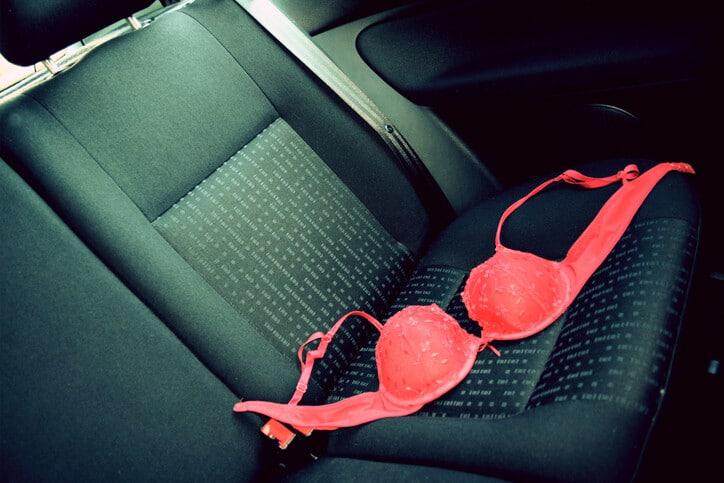 Red Bra thrown on the back seat of a car.