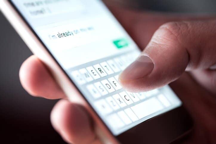 Man sending text message and sms with smartphone.