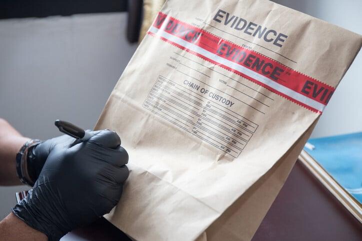 hand in glove writing on sealed evidence bag