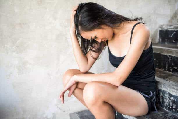 Depressed prostitute Asian woman sit on staircase. harlot girl suffered from sex abuse in abandon brothel room. Sexual harassment or rape. Social issue for poor people.