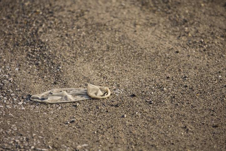A discarded condom in a beach parking lot.